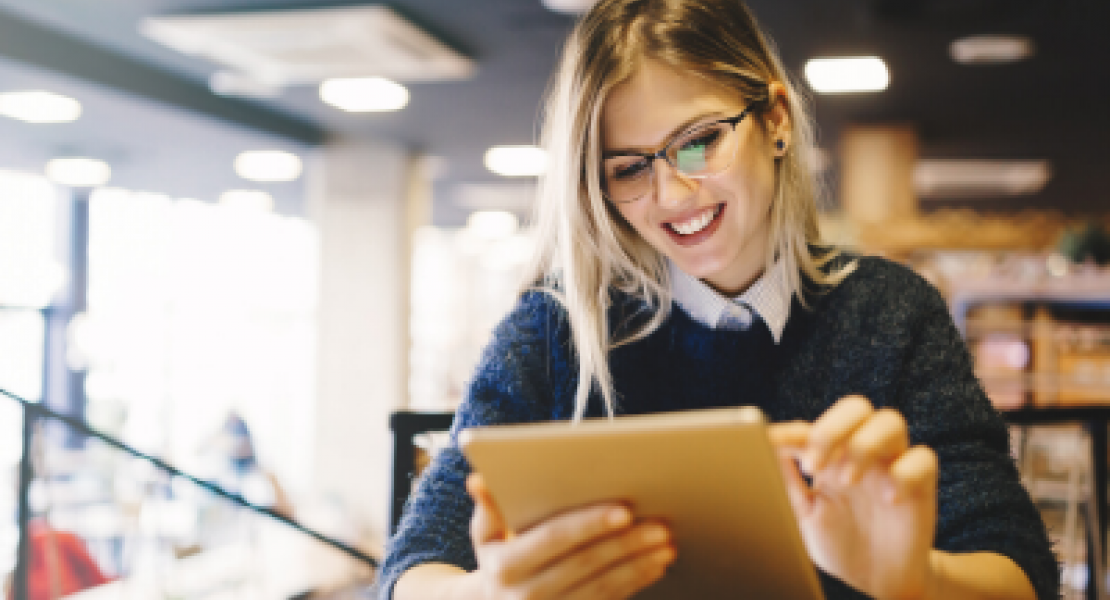Woman standing while using a tablet in a library